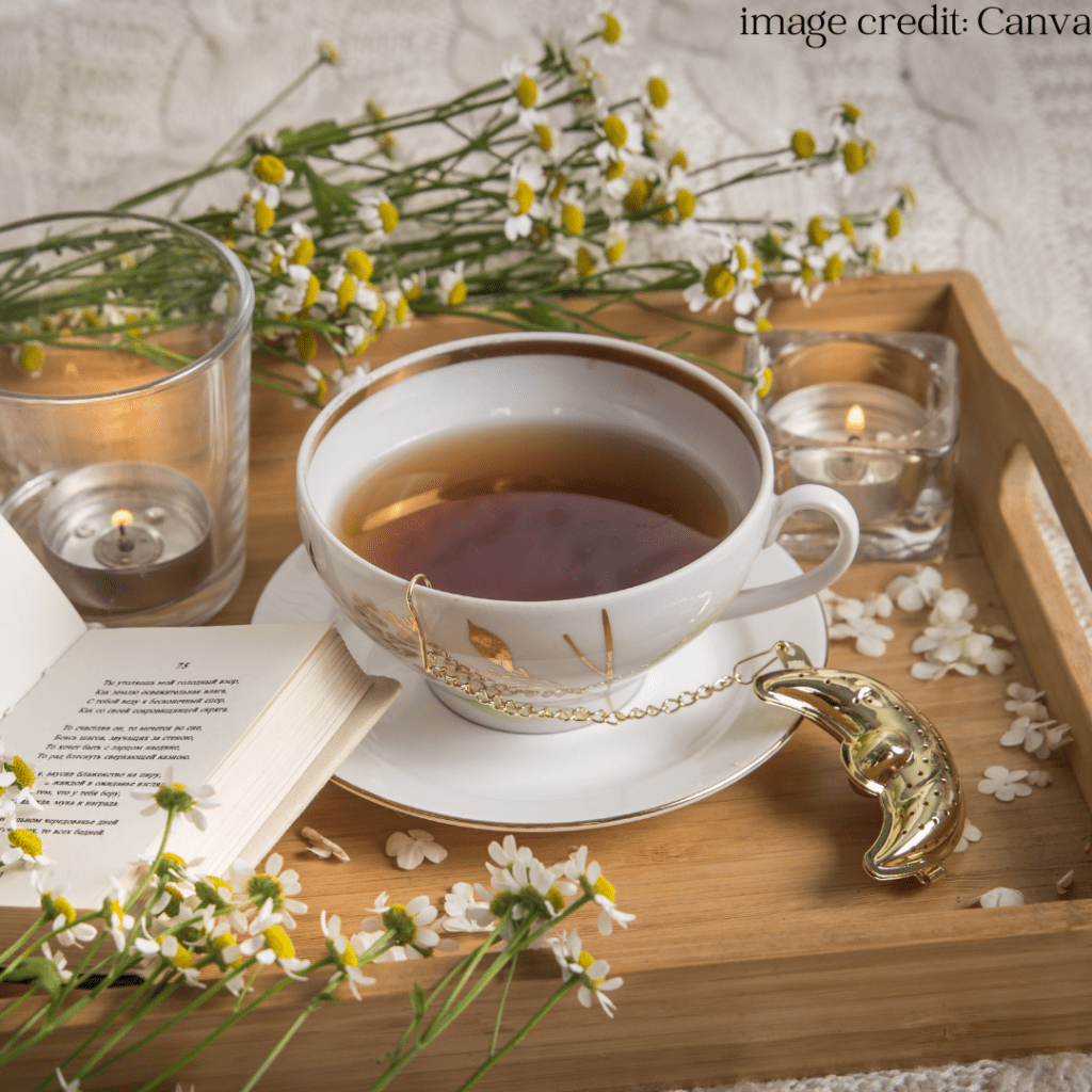 Tea in a tea cup with a book and candle